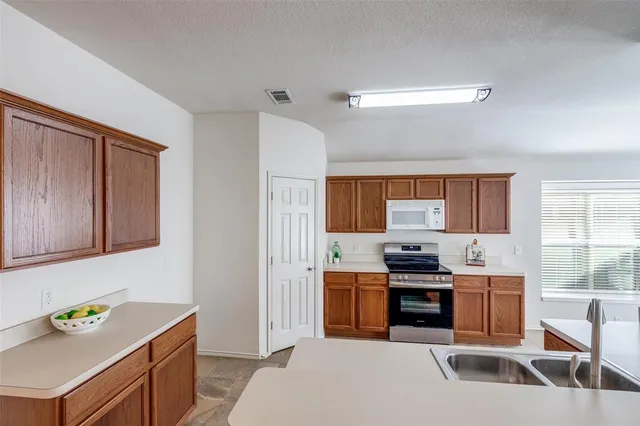 a kitchen with a sink a stove and cabinets