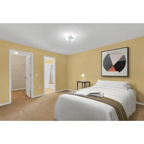 a bedroom with a bed and painting on the wall