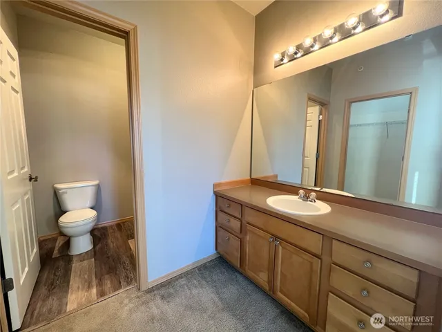 a bathroom with a granite countertop sink a toilet and a mirror