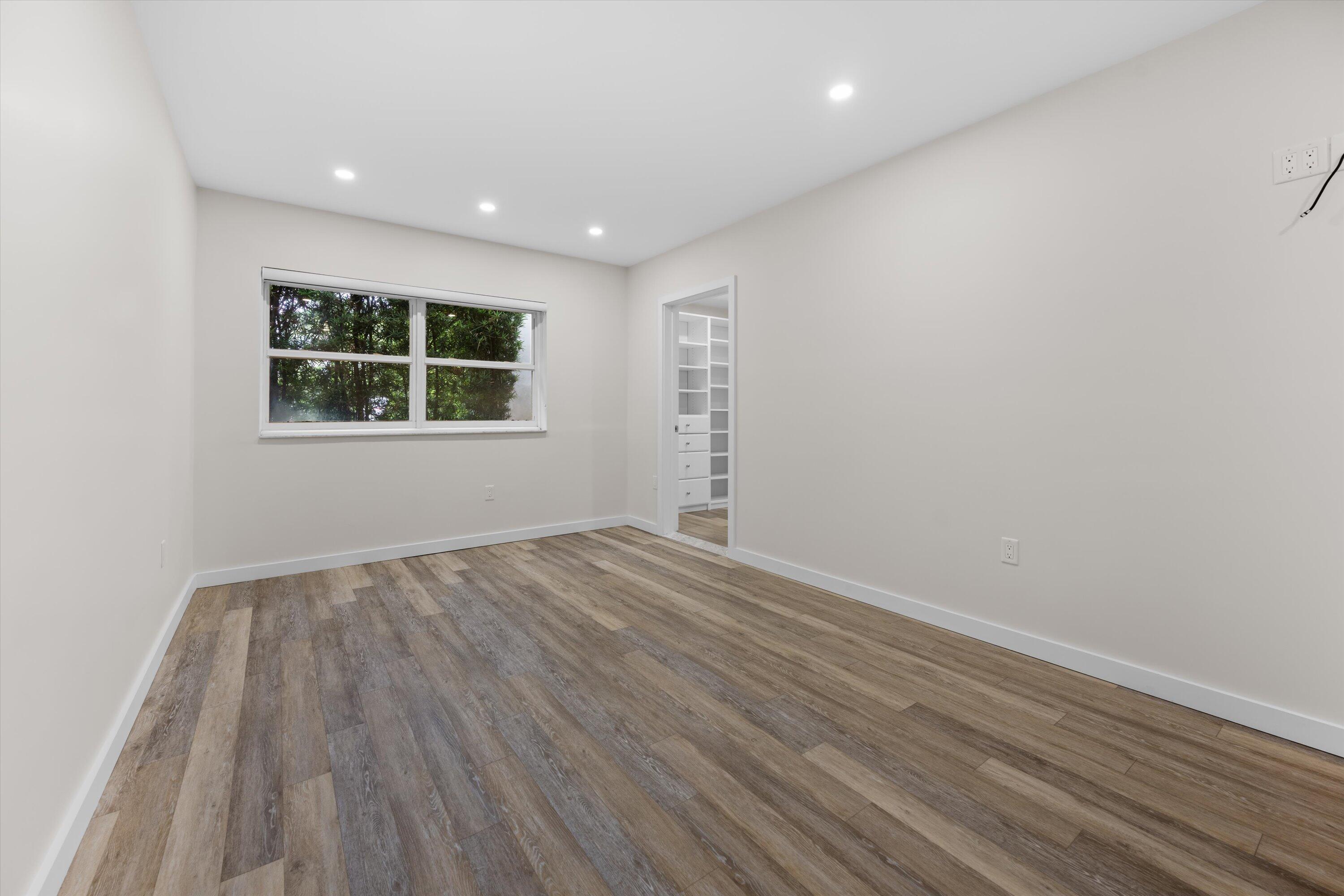 44 Cocoanut Row, Unit T27 Palm Beach, FL 33480 - Photo 12 of 40 an empty room with wooden floor and windows