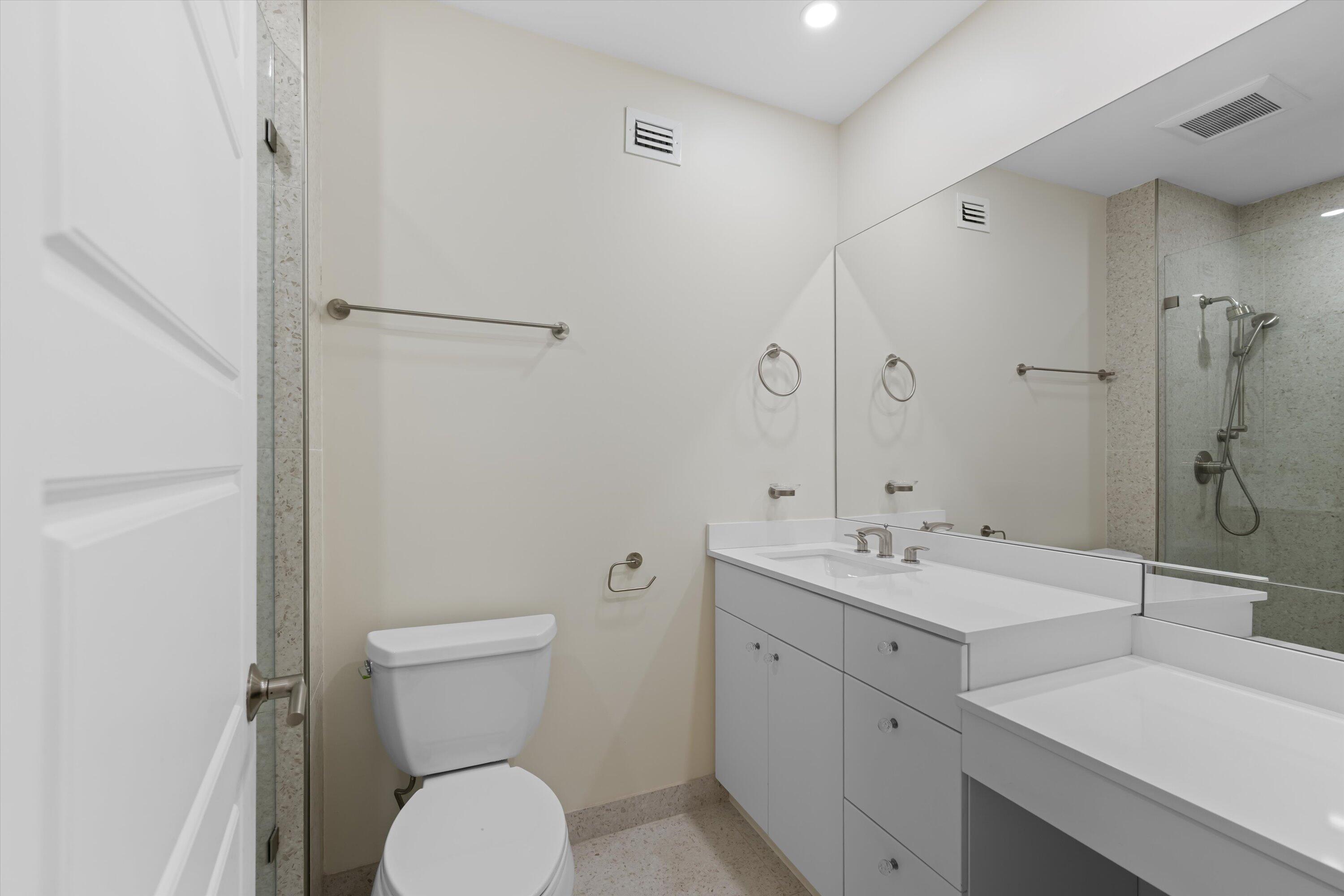 44 Cocoanut Row, Unit T27 Palm Beach, FL 33480 - Photo 14 of 40 a bathroom with a toilet sink and mirror