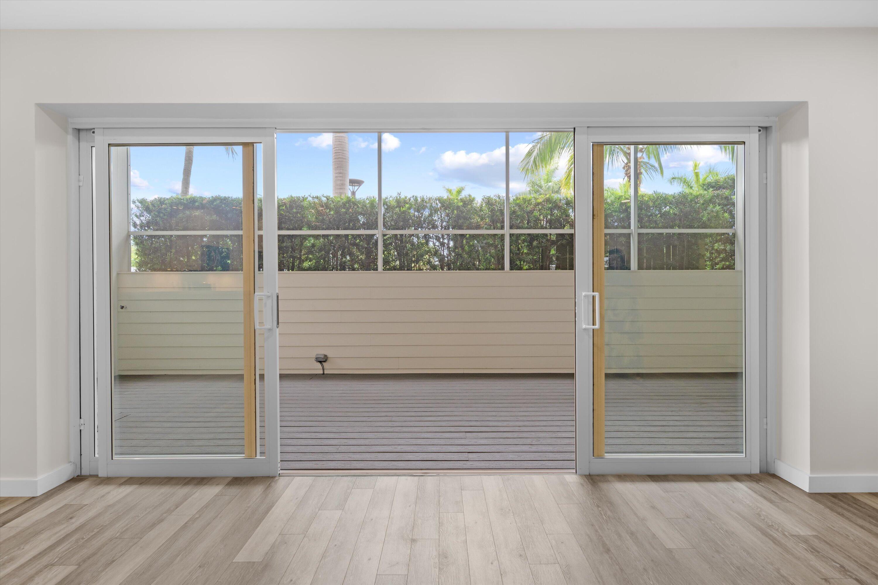 44 Cocoanut Row, Unit T27 Palm Beach, FL 33480 - Photo 7 of 40 an empty room with wooden floor and windows