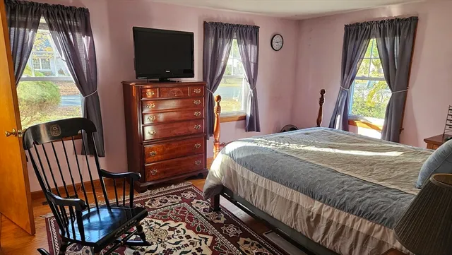 a bedroom with a bed and a flat tv screen on dresser