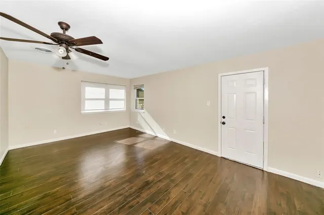 a view of a room with wooden floor and a ceiling fan
