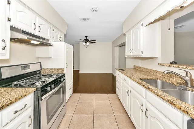 a kitchen with granite countertop a stove and a refrigerator