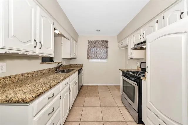 a kitchen with stainless steel appliances granite countertop a stove and a sink