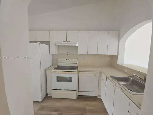 a kitchen with cabinets stainless steel appliances and sink