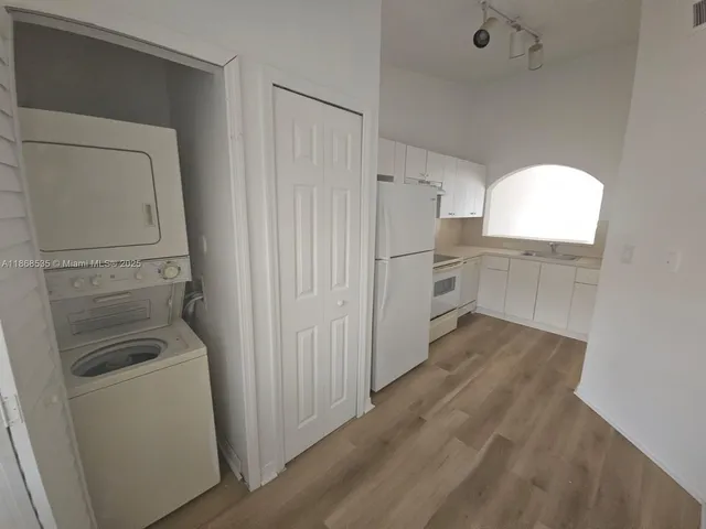 a kitchen with white cabinets and white appliances