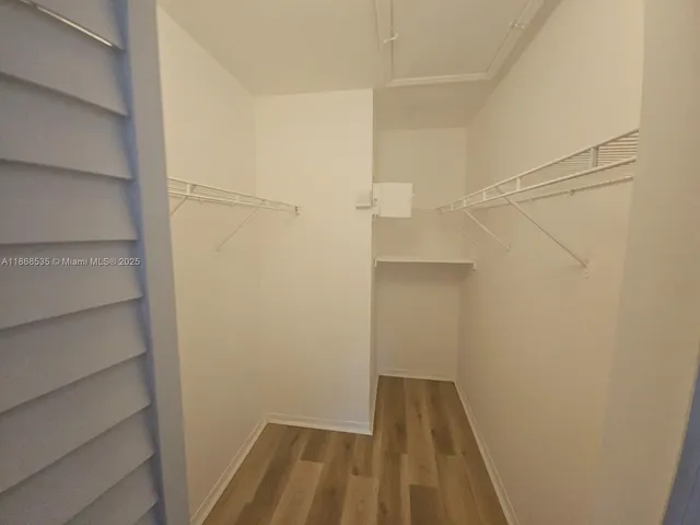 a view of walk in closet with empty racks