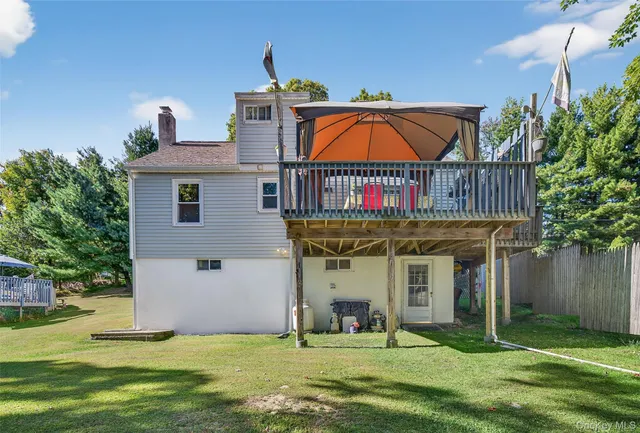 a view of a house with yard and deck