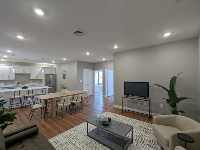 a living room with lots of furniture and a wooden floor