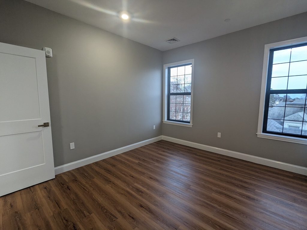 13 Nahant Street, Unit 4B Lynn, MA 01902 - Photo 15 of 28 an empty room with wooden floor and windows
