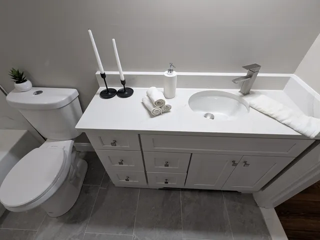 a bathroom with a double vanity sink and a toilet