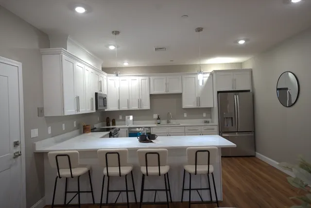 a kitchen with a table chairs refrigerator and microwave