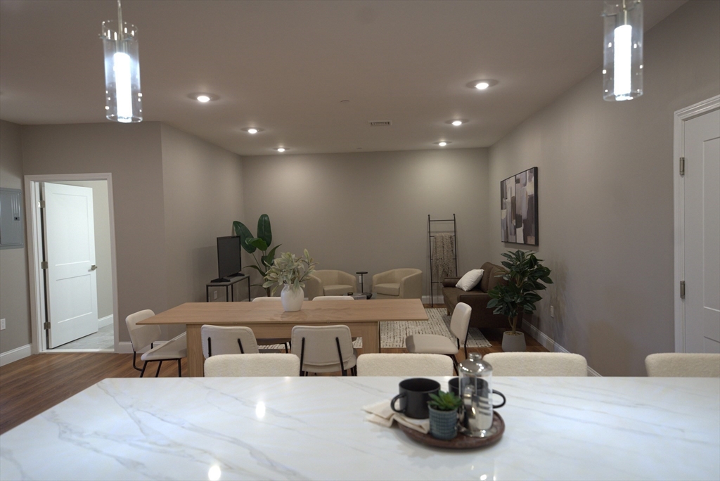 13 Nahant Street, Unit 4B Lynn, MA 01902 - Photo 5 of 28 a room with a potted plant a table and chairs