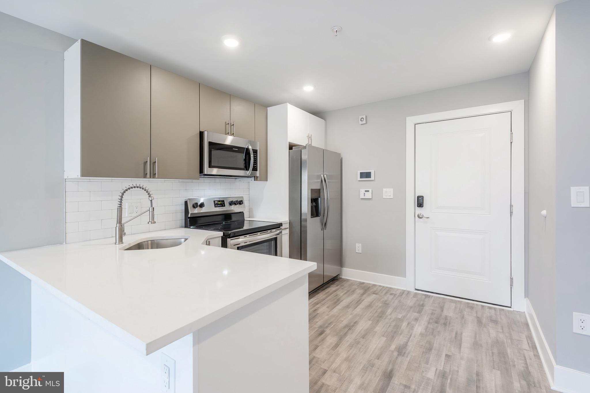 2500 North Mascher Street, Unit 9 Philadelphia, PA 19133 - Photo 4 of 17 a kitchen with stainless steel appliances a refrigerator sink and microwave