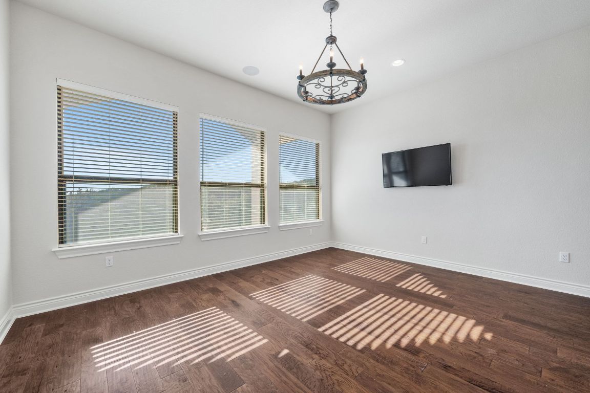 20607 Thurman Bend Road Spicewood, TX 78669 - Photo 15 of 40 Unfurnished living room featuring dark wood-style flooring, a chandelier, and recessed lighting