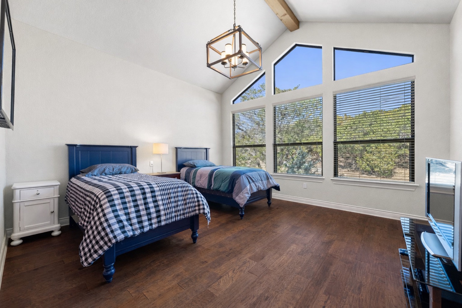 20607 Thurman Bend Road Spicewood, TX 78669 - Photo 17 of 39 a bedroom with a bed a dresser and a window