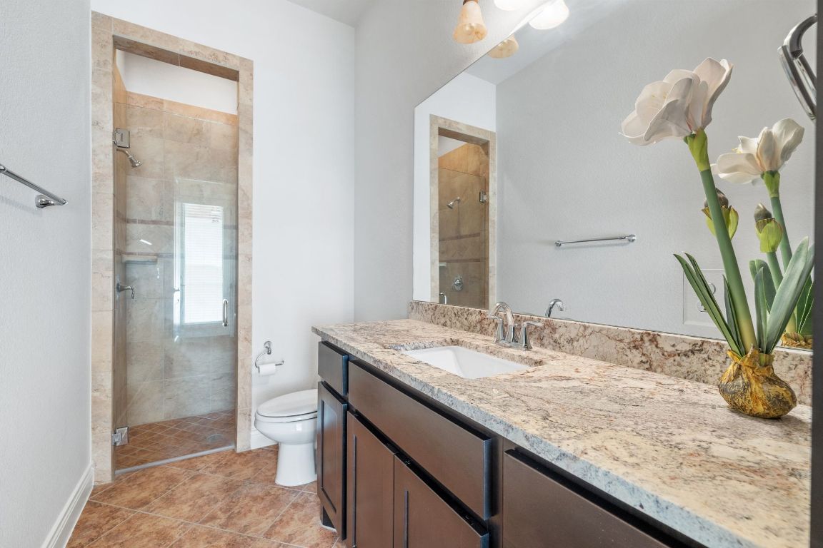 20607 Thurman Bend Road Spicewood, TX 78669 - Photo 20 of 40 Bathroom featuring a stall shower, vanity, and light tile patterned floors