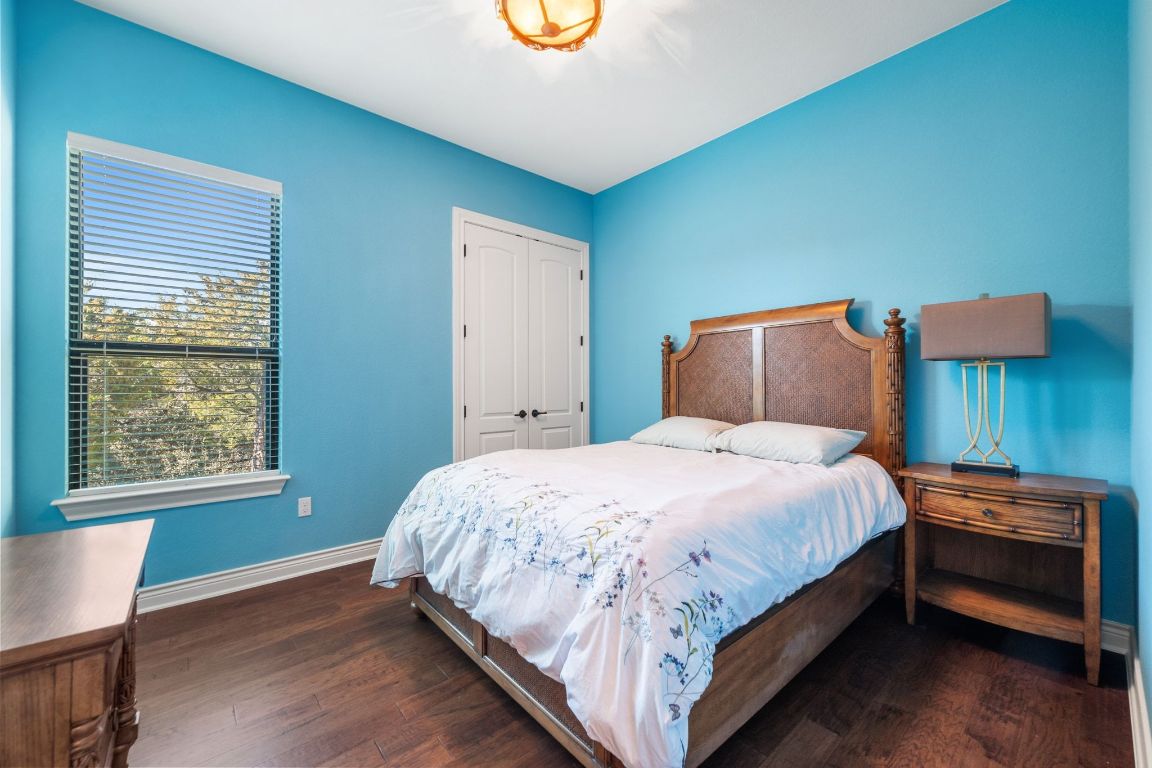 20607 Thurman Bend Road Spicewood, TX 78669 - Photo 22 of 40 Bedroom with dark wood-type flooring and a closet
