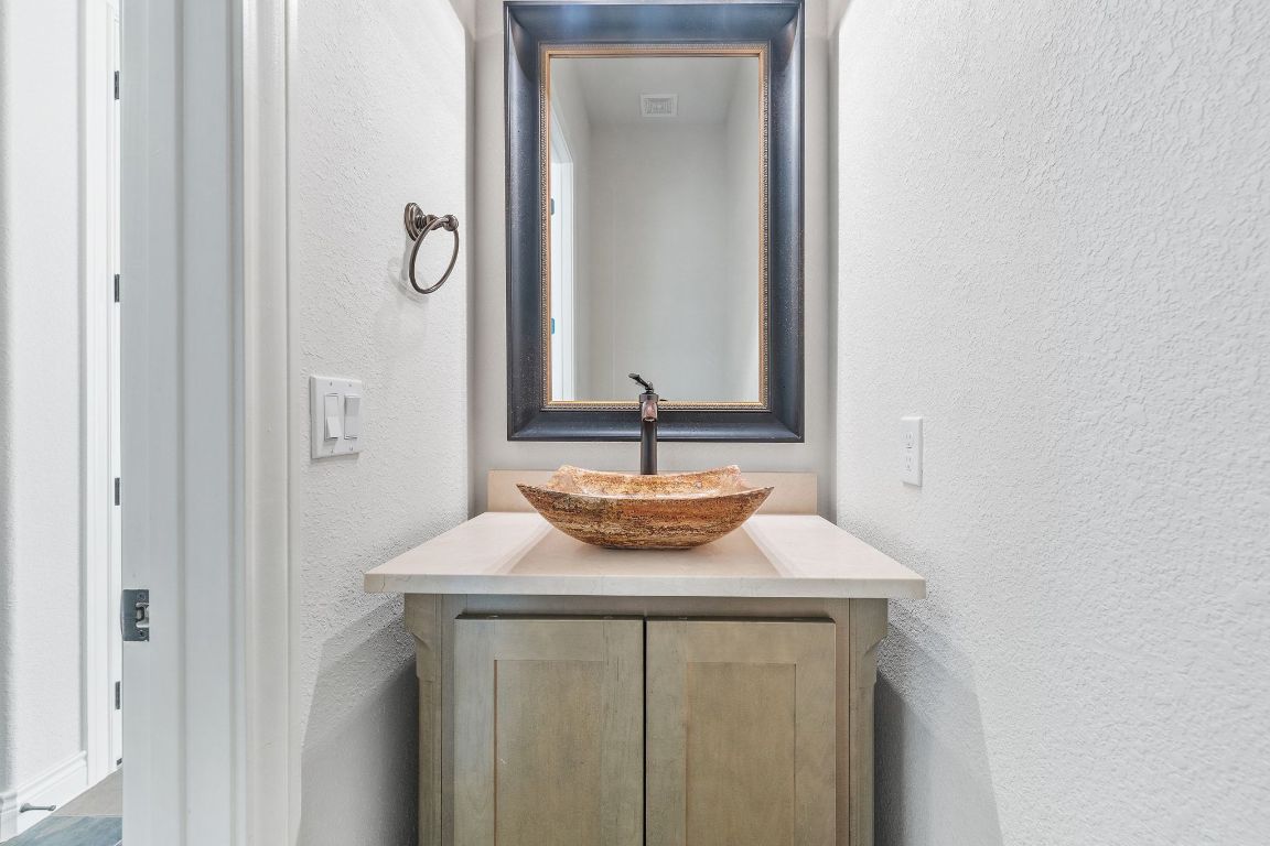 20607 Thurman Bend Road Spicewood, TX 78669 - Photo 24 of 40 Bathroom featuring a textured wall and vanity