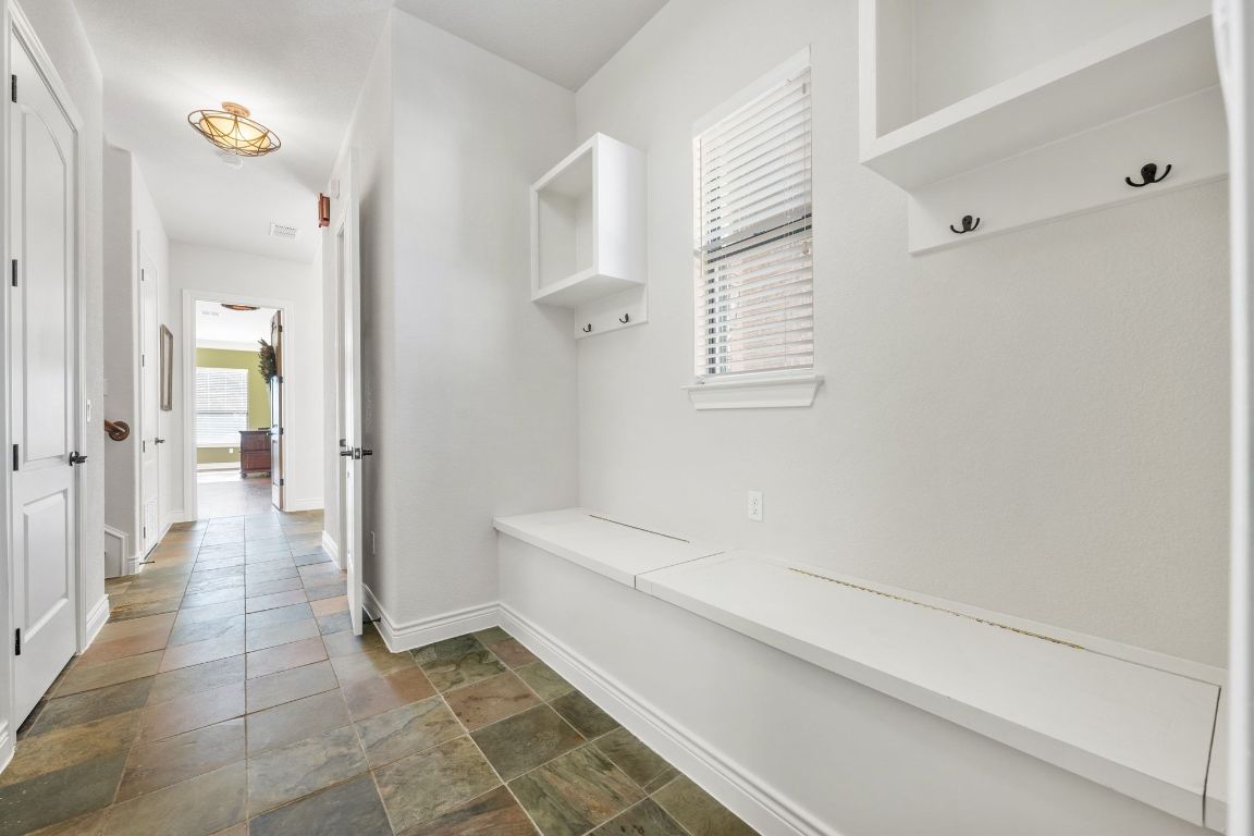 20607 Thurman Bend Road Spicewood, TX 78669 - Photo 26 of 40 Mudroom featuring stone finish flooring and baseboards
