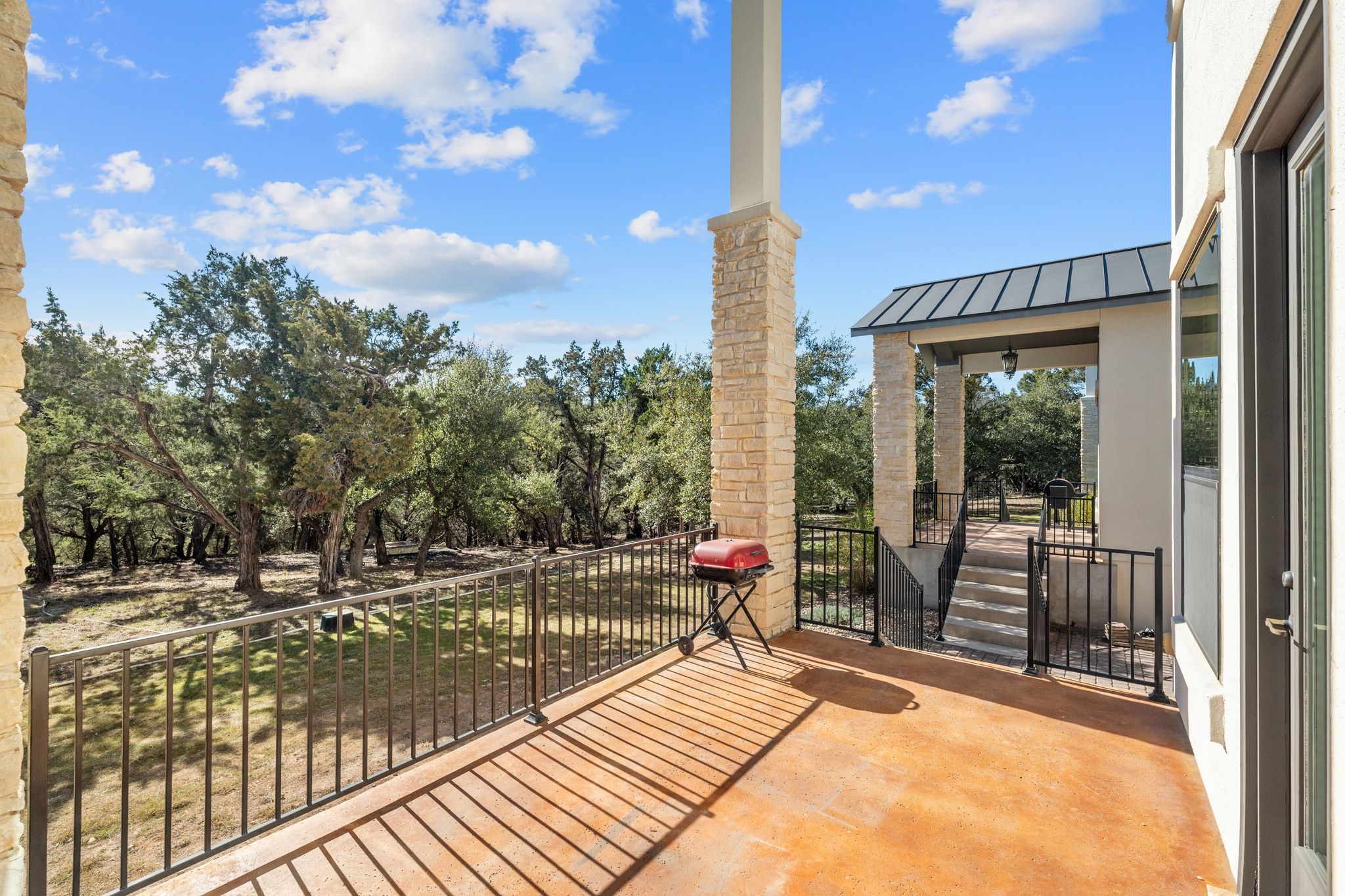 20607 Thurman Bend Road Spicewood, TX 78669 - Photo 30 of 39 a view of a balcony with floor to ceiling windows and yard