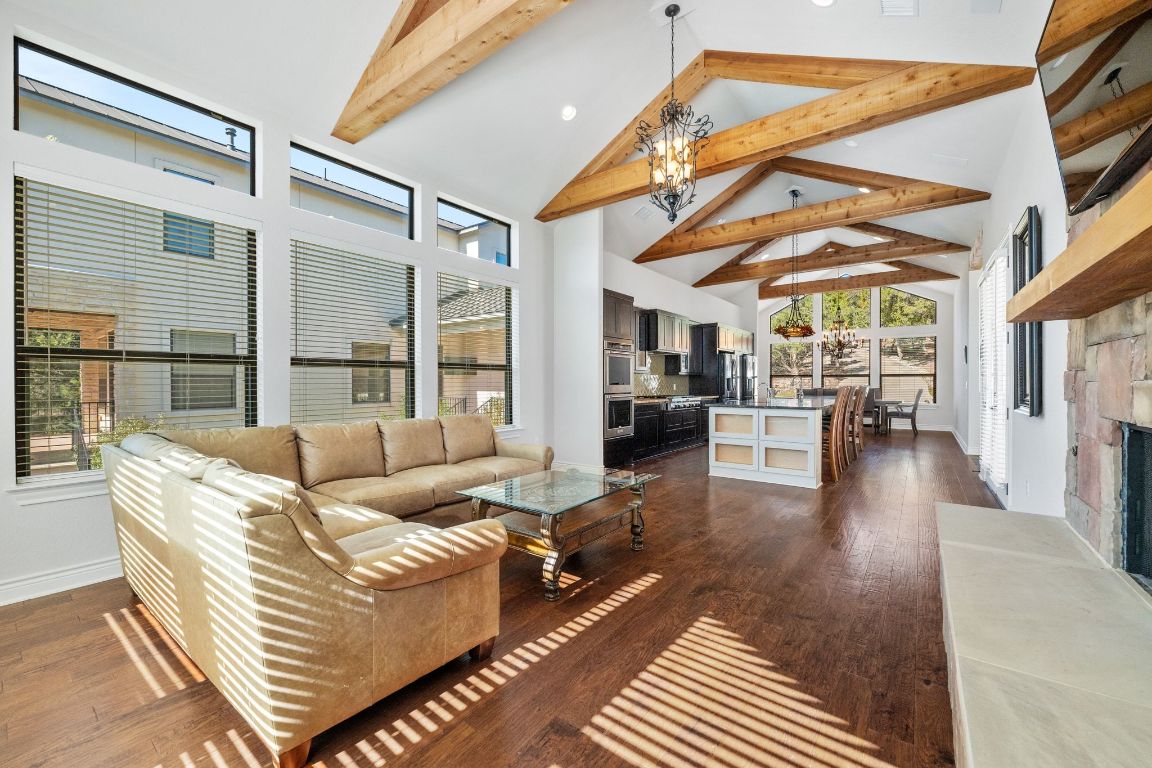 20607 Thurman Bend Road Spicewood, TX 78669 - Photo 10 of 40 Living room featuring a chandelier, high vaulted ceiling, dark wood-type flooring, recessed lighting, and a fireplace