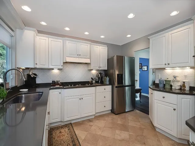 a kitchen with stainless steel appliances granite countertop a refrigerator sink and cabinets