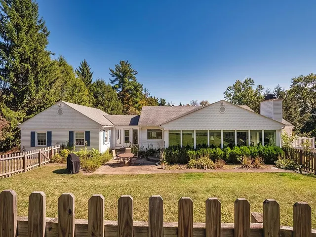 a front view of a house with swimming pool having outdoor seating