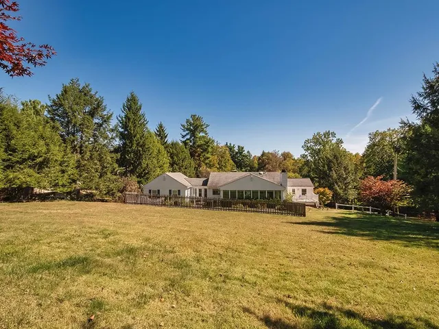 a view of swimming pool with lawn chairs and dinning table under an umbrella