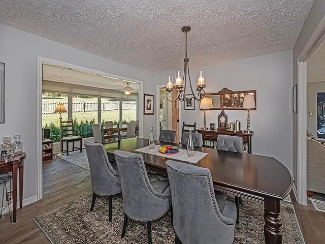 a dining room with furniture a chandelier and wooden floor