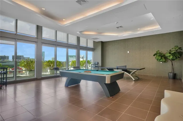 a living room with furniture a floor to ceiling window and wooden floor