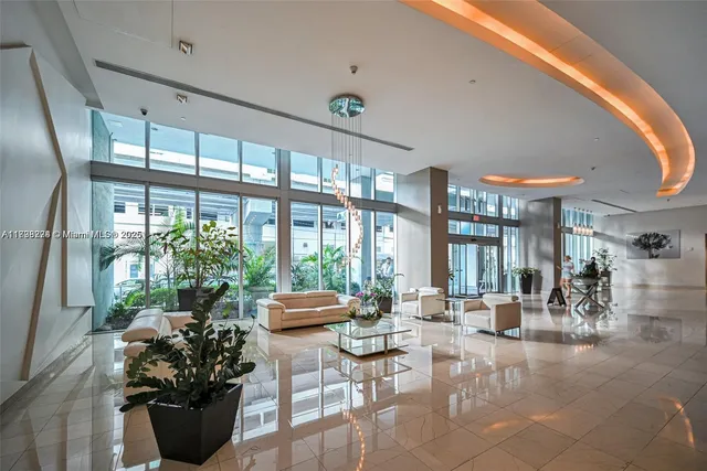 a lobby with furniture and potted plants