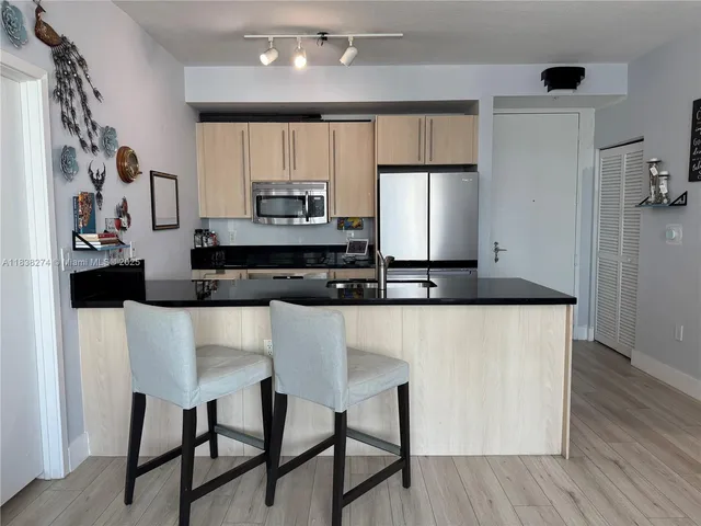 a kitchen with stainless steel appliances granite countertop a stove a refrigerator a sink and a microwave