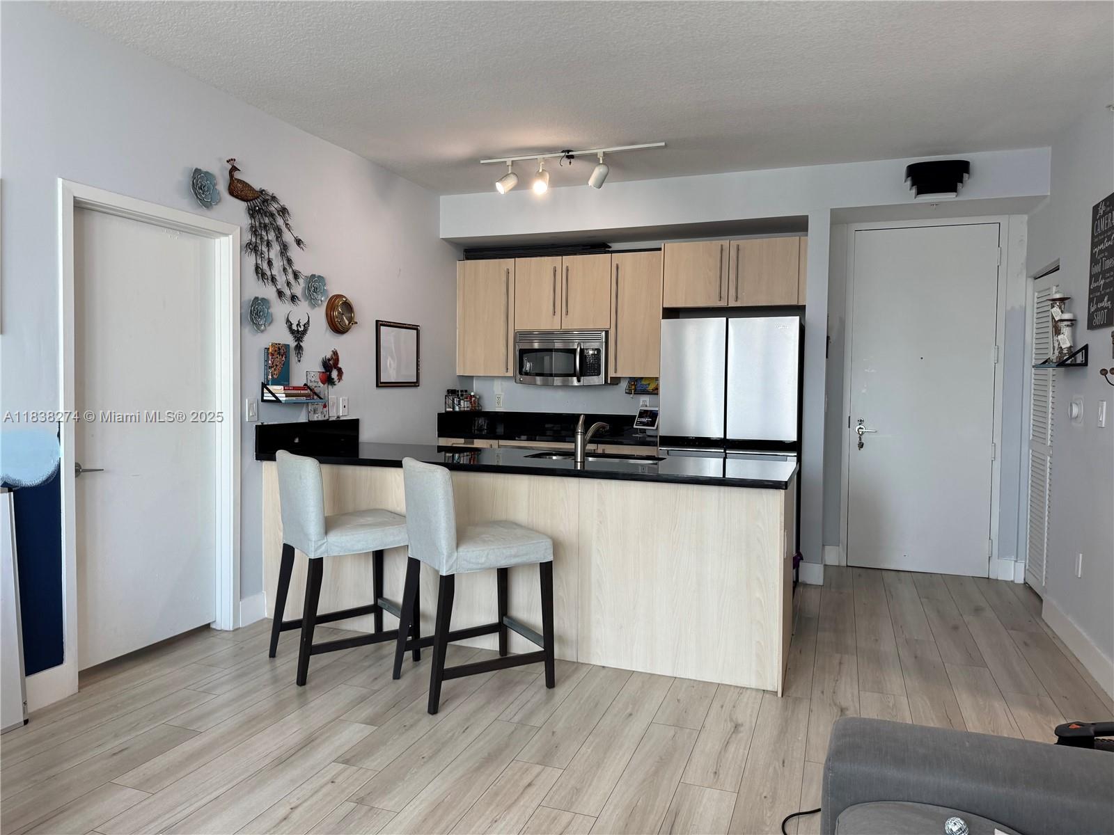 1111 Southwest 1st Avenue, Unit 2823N Miami, FL 33130 - Photo 6 of 22 a kitchen with a refrigerator and white cabinets
