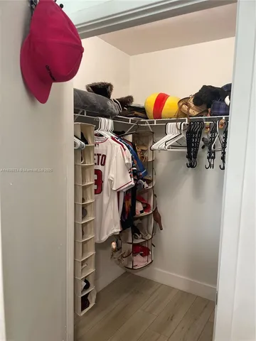 a view of walk in closet with clothes and shoes