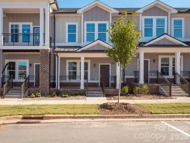 a view of a house with a patio and a yard