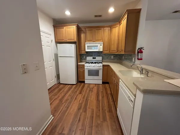 a kitchen with wooden floors and stainless steel appliances