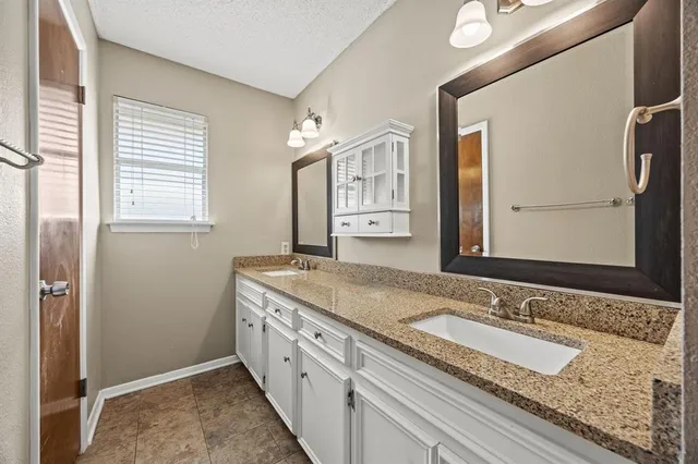 a spacious bathroom with a granite countertop sink and a mirror