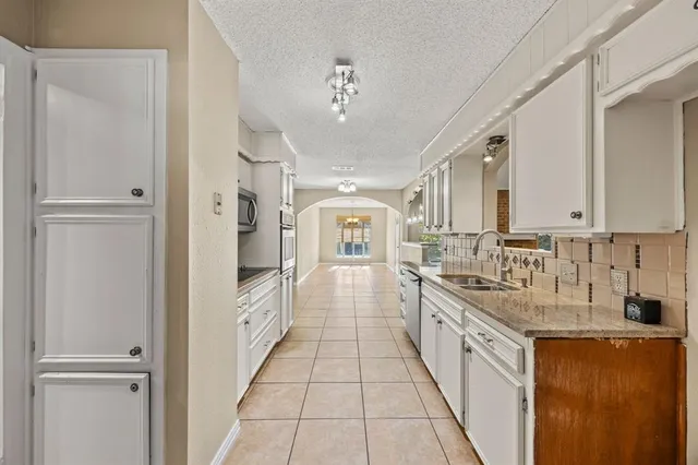 a large white kitchen with a large window