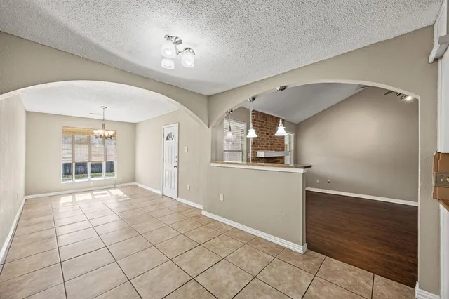 an empty room with wooden floor a fireplace and windows