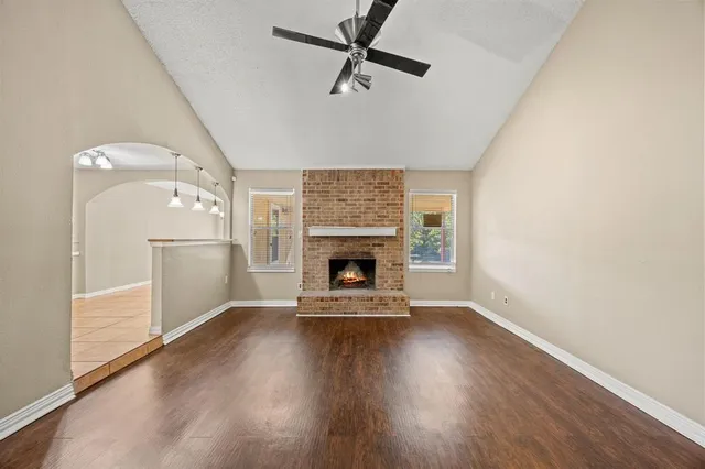 an empty room with windows fireplace and a sink