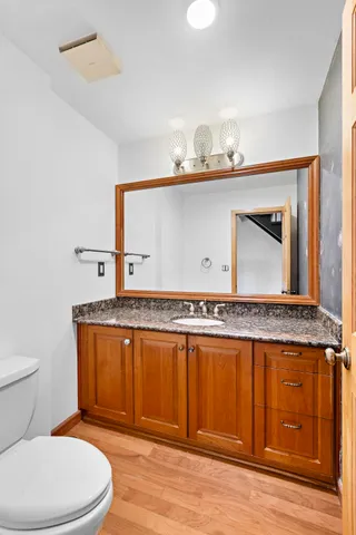 a bathroom with a granite countertop sink a toilet and a mirror