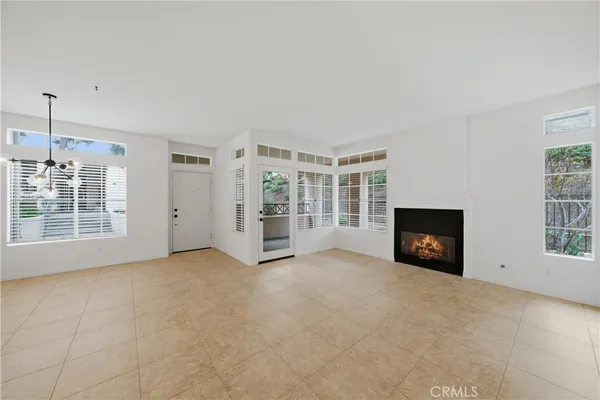 an empty room with windows and fireplace