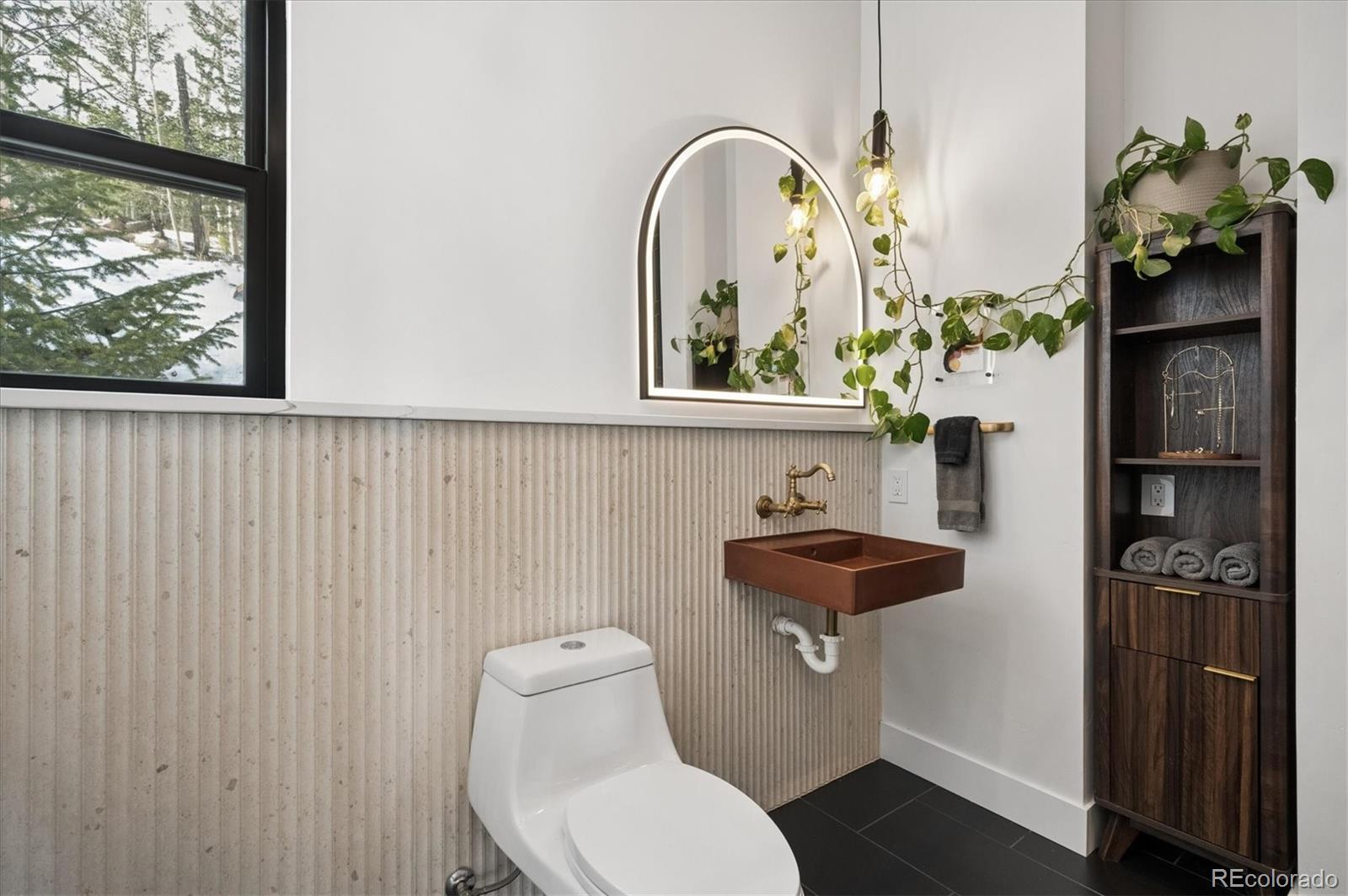 1633 Sinton Road Evergreen, CO 80439 - Photo 32 of 50 a bathroom with a toilet a sink and a window