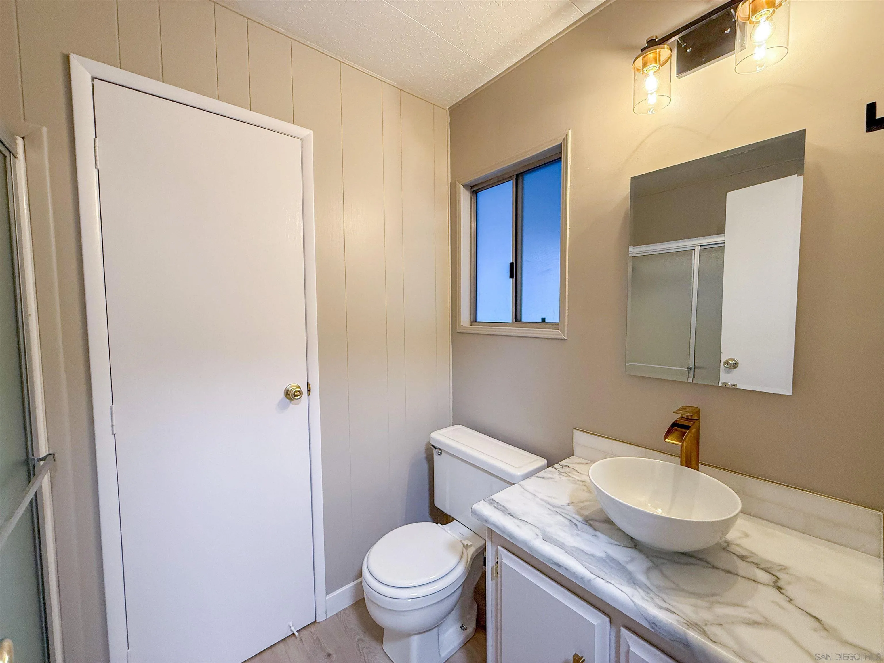1212 H Street Ramona, CA 92065 - Photo 28 of 31 a bathroom with a granite countertop sink toilet and mirror