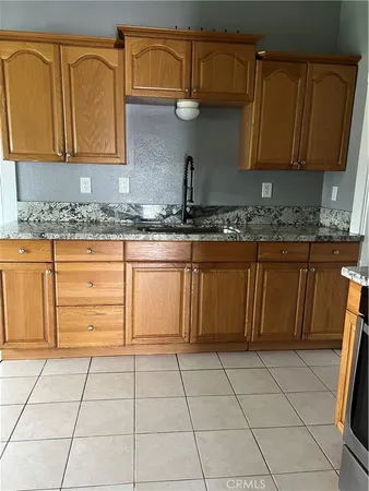 a kitchen with granite countertop a stove a sink and a microwave