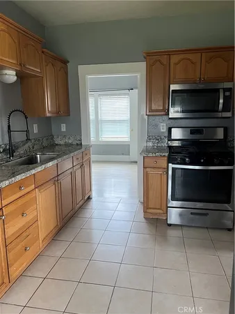 a kitchen with stainless steel appliances granite countertop a stove microwave and a sink