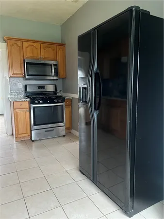 a kitchen with stainless steel appliances granite countertop a refrigerator and a stove top oven